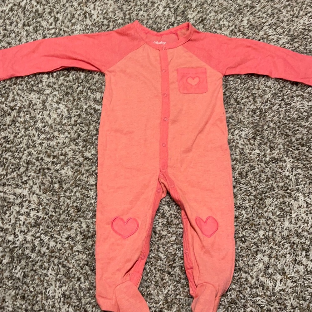 Pink button up baby girl sleeper with heart details on knee